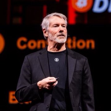 Michael Saylor, wearing a black blazer over a Bitcoin-branded t-shirt, speaks on stage with "Convention" visible in the background, delivering his stance against BIP 110 and advocating for a permissionless Bitcoin network where nodes and markets—not protocol-level rules—govern transaction validity.
