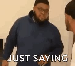 The image features a man wearing glasses, standing against a white wall with another person partially visible behind him. The text "Just saying" is written above the man's head, while the phrase "I think I might have some Pepe Card FCFs to give out talk soon." is written below his head. This suggests that the man may be discussing or planning to share some content related to the Pepe Card Football Club, which could potentially include a conversation about football or an upcoming event involving the club.

The image also contains a caption that reads "I think i might have some Pepe Card FCFs to give out talk soon." This phrase is written in white text and is located below the man's head. The caption seems to be related to the content of the image, possibly discussing or planning an event involving the club.