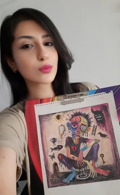 A woman with dark hair and pink lipstick takes a selfie while holding up a vibrant, surreal artwork on a clipboard featuring a colorful, distorted figure surrounded by symbolic imagery like eyes and a sun.