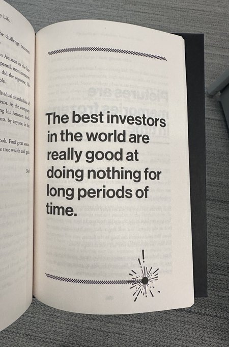A close-up of an open book displaying a bold statement: "The best investors in the world are really good at doing nothing for long periods of time." A small decorative burst graphic appears beneath the text.