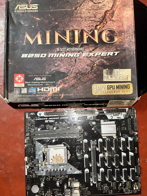 An ASUS B250 Mining Expert 19-slot motherboard box sits above the bare motherboard itself, with text highlighting 'MINING', '19-SLOT MOTHERBOARD', and '18X GPU MINING HARDWARE READY'.