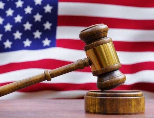 The image features a wooden gavel, which is typically used by judges or juries during court proceedings. The gavel is positioned over an American flag with stars and stripes, indicating that this scene takes place within a courtroom setting. The caption above the image reads "What is going on here? Somebody needs explaination." This suggests that there might be some confusion or uncertainty about the context of the image, possibly related to the use of the gavel in front of an American flag.

The caption also includes the words "judge" and "jury," which further supports the idea that this scene is set within a court proceeding. The gavel's position over the flag might be intended as a symbolic gesture or a visual representation of the judge or jury's authority in making decisions based on the law, similar to how the flag represents the nation's unity and adherence to its principles.