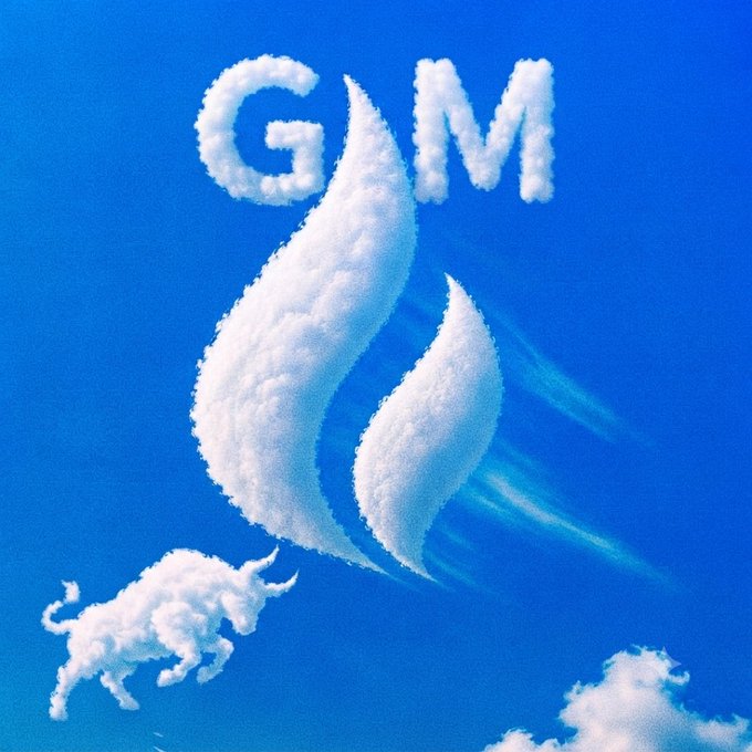 A cloud-sculpted bull charges toward a fiery flame logo with "GM" spelled out in clouds against a blue sky, visually representing the choice between "gm" (good morning, bullish) and "ngmi" (not going to make it) — the bull symbolizing the winning, optimistic path.