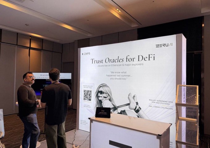 Two men stand near a ZERU AI booth displaying 'Trust Oracles for DeFi' with a QR code, promoting a ZScore live on Ethereum.