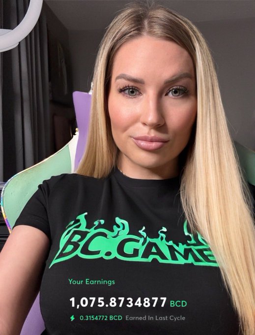A blonde woman wearing a black t-shirt with 'BC.GAME' printed in green text smiles at the camera, with overlaid text showing 'Your Earnings 1,075.8734877 BCD'.