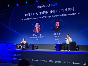 Two presenters sit on stage at XRP Seoul 2026 for a fireside chat titled "The Agentic Economy on the XRP Ledger: From Use Cases to Adoption," with speaker headshots and names displayed on the large screen behind them.
