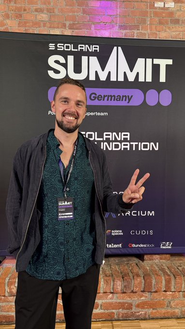 The image shows a smiling man making a peace sign at the "SOLANA SUMMIT Germany" event, with sponsor logos like Solana Foundation, ARCIUM, CUDIS, and Bundesblock visible behind him. This visual aligns with the post's narrative of Solana evolving beyond its "casino chain" reputation, capturing the energy of the Berlin summit where discussions centered on tokenized stocks, stablecoins, and real-world assets.