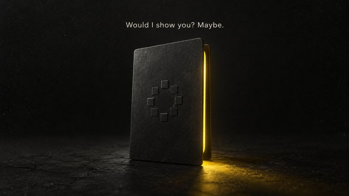 A black notebook or card featuring an embossed geometric logo stands against a dark background with yellow light spilling from behind it, accompanied by the text "Would I show you? Maybe."