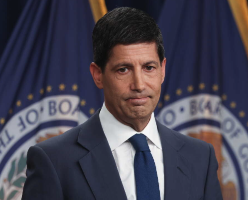 Paul Ryan stands in front of U.S. House of Representatives flags, his expression serious, accompanying a news update on the Federal Reserve's unanimous decision to raise interest rates by 25 basis points and revise its inflation-targeting language.