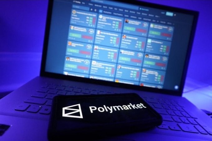 The image shows an open laptop computer with its screen displaying data from Polymarket, a platform that tracks real-time market changes. The laptop has a wallet attached to its keyboard for easy access while using the device. The content on the screen includes various charts, graphs, and text related to the progress of Polymarket over the past year. Based on this information, it can be inferred that the popularity of the platform is growing rapidly as more people recognize its value in providing real-time market data for trading purposes.