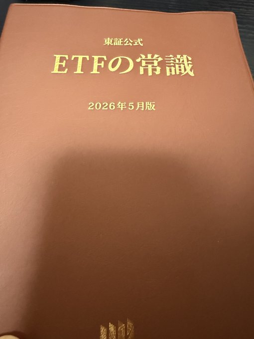 A brown hardcover book titled "東証公式 ETFの常識" (Tokyo Stock Exchange Official: ETF Basics), May 2026 edition, sits on a surface—being reread in preparation for an upcoming Financial Instruments and Exchange Act event focused on Bitcoin at TokyoBitcoinBase.