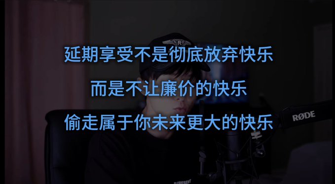 A person sitting in front of a microphone with Chinese text overlaid that reads '延期享受不是彻底放弃快乐 而是不让廉价的快乐 偷走属于你未来更大的快乐'.