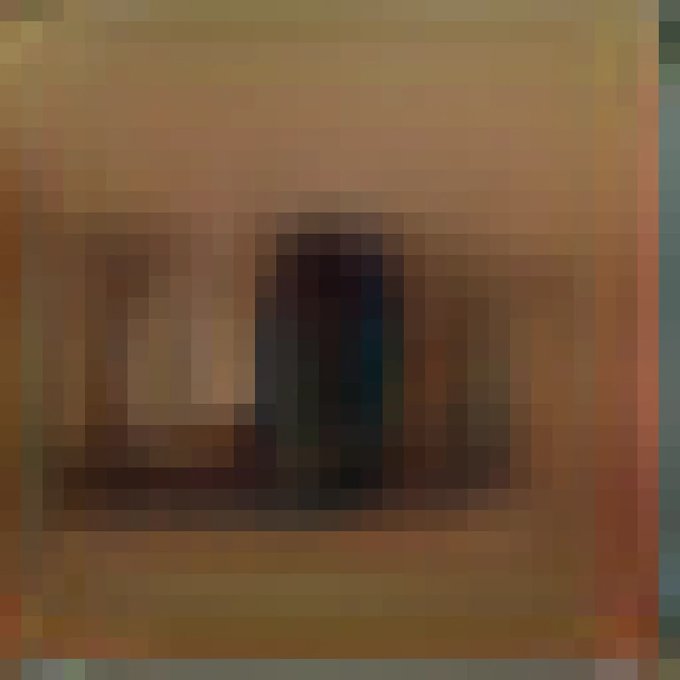 A highly pixelated, abstract image consisting of blocky shades of brown, orange, and dark blue, forming an indistinct shape.