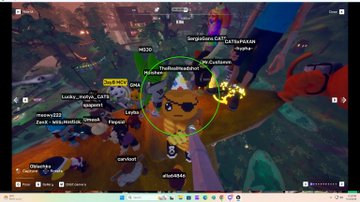 A colorful real-time strategy video game map view with numerous player usernames visible around a central green character.