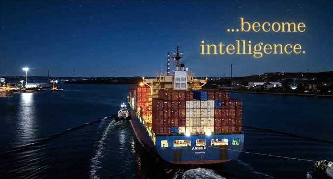 An aerial nighttime photograph of a cargo ship named 'ANNA B' loaded with containers, with glowing text overlaid reading '....become intelligence.'
