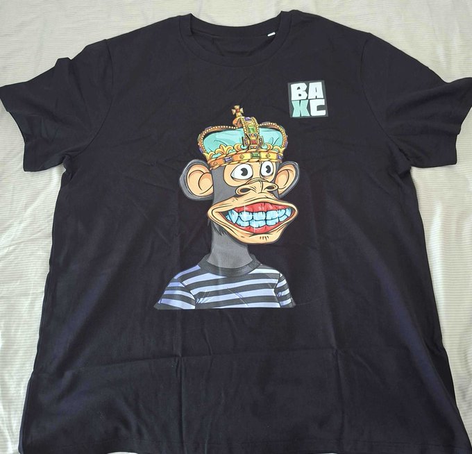 A black t-shirt featuring a cartoon monkey wearing a crown and striped shirt, with 'BAKC' text in the upper right corner.