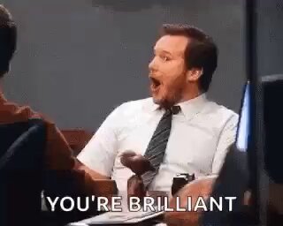 The image features a man sitting at a desk with his mouth open wide, seemingly surprised or excited about something. The text "You're brilliant" is written above him, indicating that he is being recognized for his brilliance. The background of the image shows a person's face and another person's arm, suggesting that they are in an office setting where the man has just made a significant discovery or achievement related to cryptocurrency.