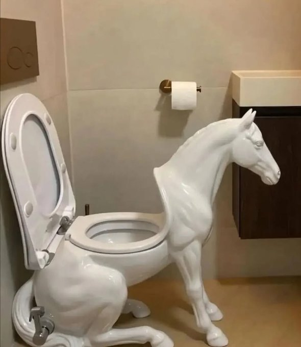 The image features a bathroom with a toilet that has been designed as a horse. The toilet seat is open, revealing the horse's legs and body inside the bowl. A roll of toilet paper can be seen next to the toilet, along with a sink in the background. There are also two signs present in the scene: one sign reads "When $WLD hits $10, I won'n tell anyone... but there will be signs." This suggests that the bathroom is part of an art installation or a unique design concept, and the presence of these signs implies that visitors should pay attention to their surroundings.

The image also contains some text about a horse in a toilet, which adds to its artistic nature. The combination of the horse-themed toilet with the accompanying signs creates an interesting and unusual scene within the bathroom space.
