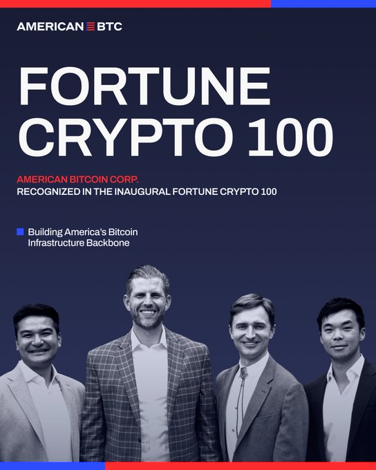 The image features a group of four men standing next to each other, all dressed in suits and ties. They are positioned against a blue background with red text that reads "American Bitcoin Corp." The men appear to be posing for a photo or participating in an event related to cryptocurrency.