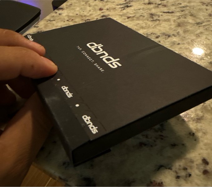 A hand holds a black subscription box labeled 'abnds' with the tagline 'TIP. CONNECT. SHARE.' resting on a granite countertop.