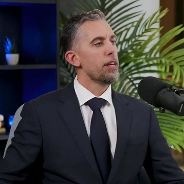 A man wearing a suit and tie is talking into a microphone, sitting at a desk with some plants around him. A blue light can be seen in the background behind him. There are several potted plants scattered throughout the room along with the man's chair. The image presents an indoor scene where it appears that he might be giving a talk or hosting an event related to cryptocurrency. Strategy, as suggested by one of the statements within the image, would need to buy approximately 135,000 Bitcoins in order to match the pace at which his holdings are growing.