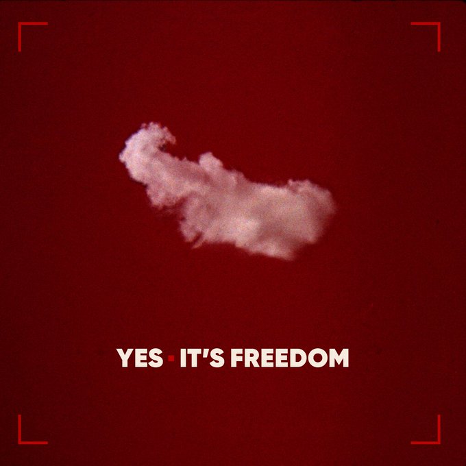 A single white cloud floats in a deep red sky above the text 'YES · IT'S FREEDOM', framed by red viewfinder-style corner brackets.