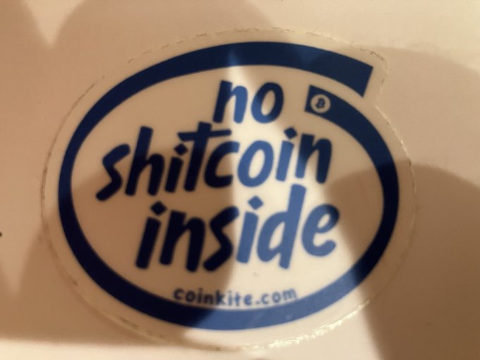 A close-up of a sticker with blue text reading 'no shitcoin inside' and 'coinkite.com'.