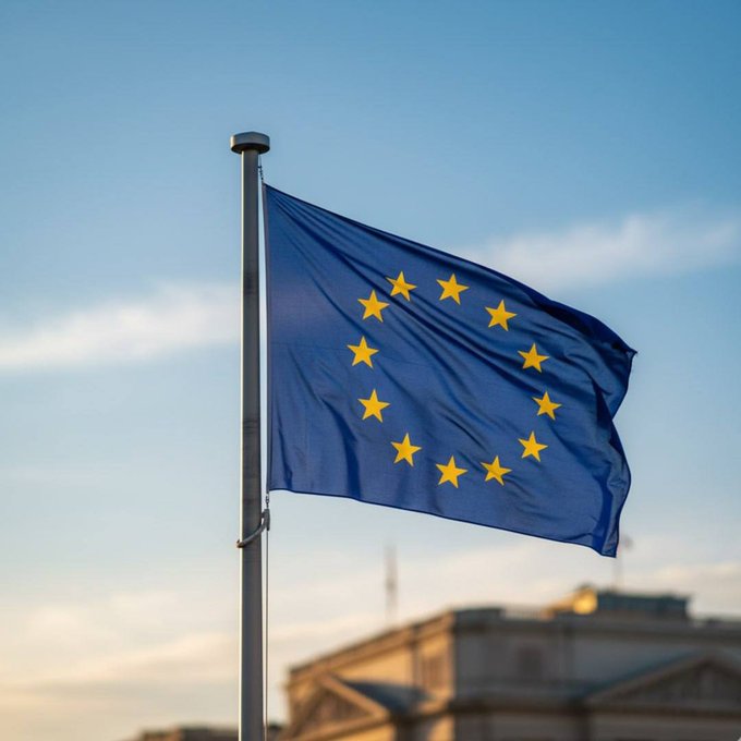 The flag of the European Union waves against a blue sky, symbolizing the EU's regulatory authority as it expands sanctions to ban transactions with 14 crypto platforms across Georgia, Panama, the UAE, the Marshall Islands, Kyrgyzstan, and Belarus.