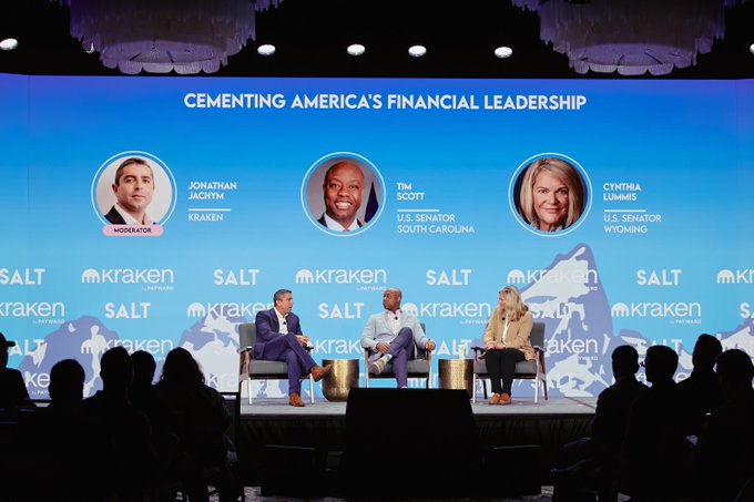 A panel discussion titled 'CEMENTING AMERICA'S FINANCIAL LEADERSHIP' featuring moderator Jonathan Jachim (Kraken), U.S. Senator Tim Scott (South Carolina), and U.S. Senator Cynthia Lummis (Wyoming) at a SALT/Kraken conference.