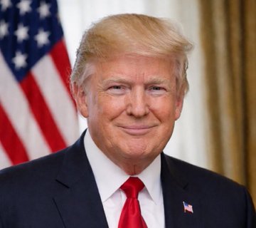 An official portrait of Donald Trump in a dark suit with red tie, standing in front of an American flag.
