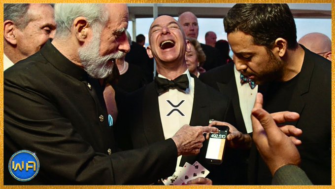 The image shows a group of people gathered around, with one man wearing a black suit and bow tie holding up an XRP coin. The other two men are laughing at him as he holds up the coin. In the background, there are several other people present in the scene.