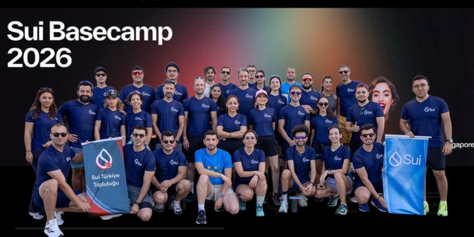A group photo from 'Sui Basecamp 2026' showing attendees in blue shirts holding banners, including one reading 'Sui Türkiye Topluluğu'.