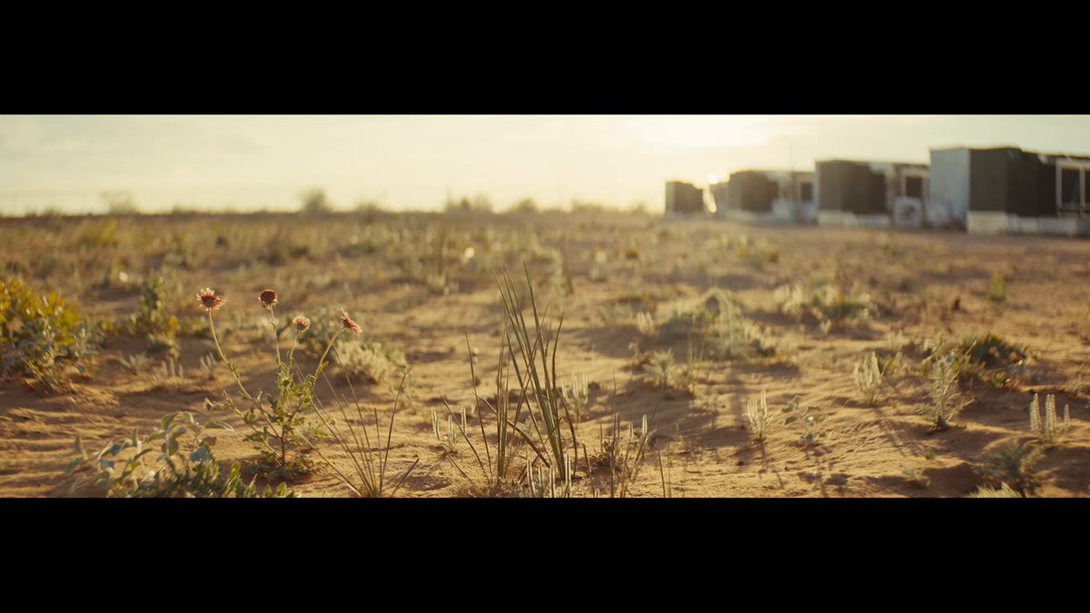 The image shows a desert landscape with a long, straight road running through it. In the background, there are several buildings or structures that appear to be made of concrete or other similar materials. The sun is shining brightly over the scene, casting shadows on the ground and highlighting the dryness of the environment. The image also contains text elements such as "DATUM on OCEAN Lower bandwidth. Fewer stale shares. Reduced latency. More BTC. Sovereign blocks. Mining in the middle of nowhere never felt so good." This suggests that there might be a connection between the desert landscape and the world of cryptocurrency, possibly indicating an interesting or unusual intersection between these two topics.