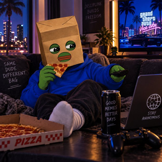 A Pepe the Frog character with a paper bag over its head sits on a couch eating pizza and holding a controller, with a Grand Theft Auto: Vice City screen, a 'STAY ANONYMOUS' laptop, and a 'GOOD MEMES BETTER DAYS' energy drink nearby.