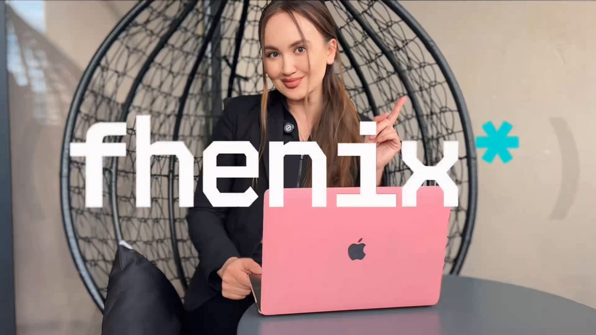 The image features a woman sitting at a table with her laptop open, smiling as she points towards something. The background of the image shows an advertisement for a privacy-focused app called "fhenix", which has been described as a tool that helps users keep their data private by analyzing it and sending the results to them securely.