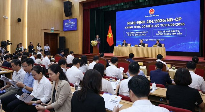 A formal government conference in Vietnam with a large blue screen displaying 'NGHỊ ĐỊNH 284/2026/NĐ-CP' regarding foreign exchange and banking, dated 'ngày 01 tháng 9 năm 2026', with officials seated at a front table and attendees in the audience.