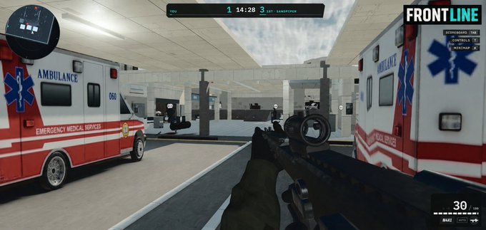 A first-person shooter video game screenshot showing the player holding a rifle in a modern medical facility, with ambulances marked "EMERGENCY MEDICAL SERVICES" and "AMBULANCE 066" visible on either side; the UI displays "FRONTLINE" and a scoreboard showing 14:28 remaining.