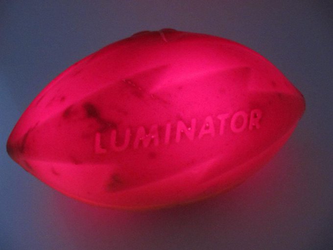 A glowing red translucent object with the word 'LUMINATOR' embossed on it against a dark background.