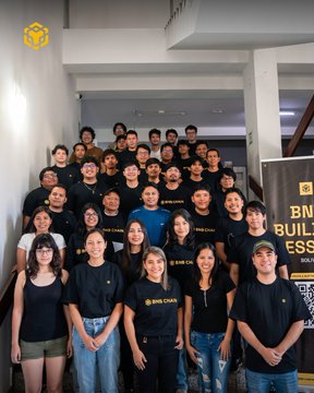A large group of young people wearing black 'BNI Crew' t-shirts pose together for a group photo in what appears to be an office or building lobby with a 'BNI Builders' banner.