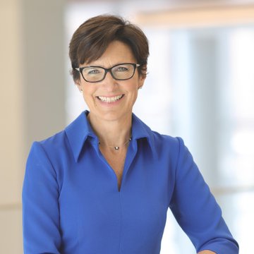 A woman in a blue blouse and glasses smiles confidently in this professional headshot, identified as Citi CEO Jane Fraser, who is shown here in connection with her recent warning that the CLARITY Act's stablecoin rewards program could divert deposits from smaller banks and reduce lending access in certain U.S. regions.