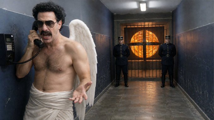 A humorous scene of a shirtless man with angel wings and sunglasses yelling into a wall-mounted phone in a prison hallway, with two guards standing by a gated door in the background.