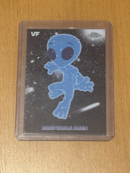 A Topps Chrome VeeFriends trading card featuring a blue "Adaptable Alien" character in a clear plastic sleeve, displayed on a wooden surface. The post highlights the buyer's preference for purchasing desired VeeFriends cards directly (such as this "Adaptable Alien") on eBay rather than gambling by ripping packs.