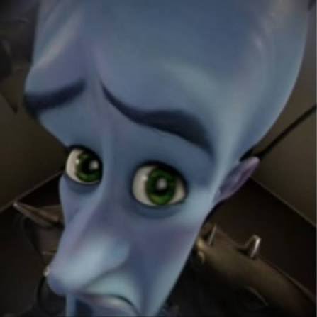 A close-up of Megamind, the blue animated character from the movie, with green eyes and an exaggerated facial expression.