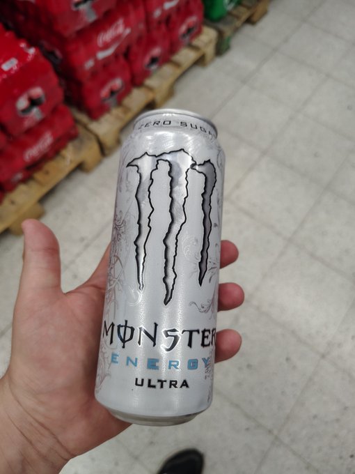 A hand holds a silver can of Monster Energy Ultra Zero Sugar in what appears to be a warehouse store, with pallets of red Coca-Cola cases stacked in the background. The caption and image together suggest the person is fueling up on energy drinks while making a bold, high-risk bet on a Pepe (likely $PEPE) cryptocurrency position, marking it as their "final try."