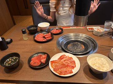 A person celebrates their X earnings by treating themselves to a yakiniku meal, with an assortment of raw beef plates, dipping sauces, rice, and a grill ready at the table.