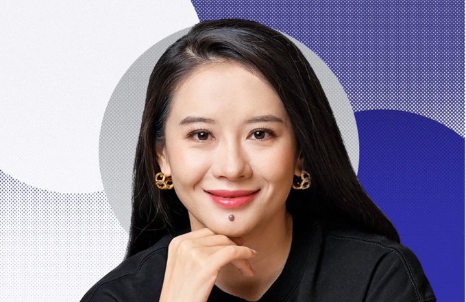 The image features a woman with long dark hair wearing black clothing, posing for a picture against a blue background that includes circles of varying sizes. The woman has her hand resting on her chin while looking at the camera. The caption below the photo reads "看到 @heyibinance 入选《财富》商界女性榜单", which suggests that she is promoting a product or service related to finance and investing.