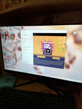 A computer monitor displaying a desktop screen with a game or app interface, with a keyboard visible below.