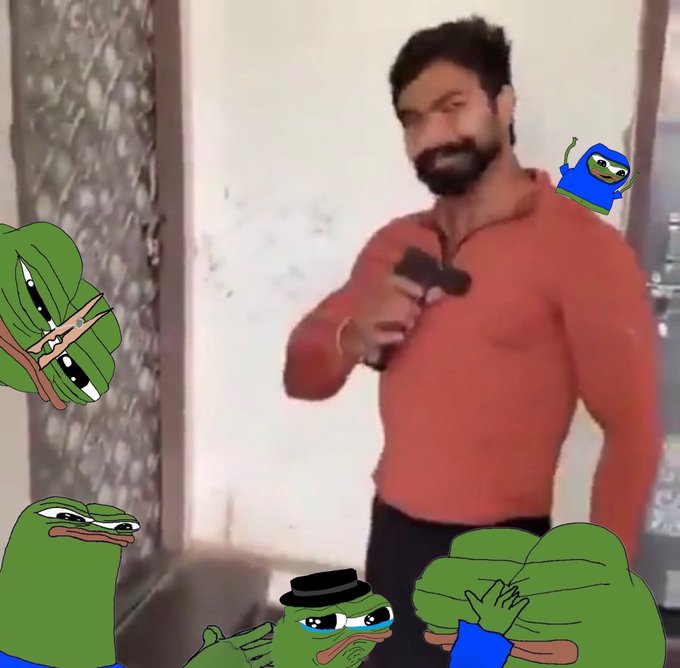 A muscular man with a beard wearing a red zip-up sweater stands holding what appears to be a dumbbell, while several Pepe the Frog meme characters are digitally added around the image, including a small dancing Pepe.