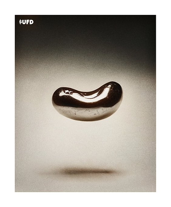 A dark, glossy bean-shaped object floats above a gradient surface with the text "$UFD" in the upper left corner.