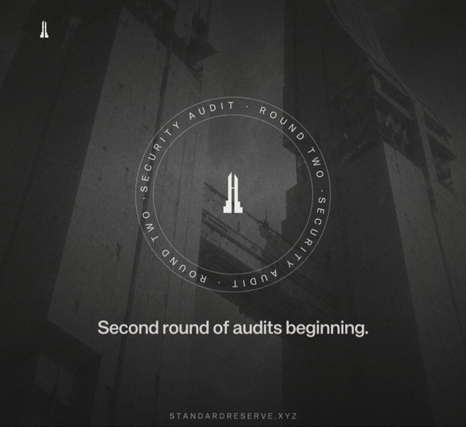 A dark grayscale announcement graphic stating 'Second round of audits beginning' for 'standardreserve.xyz', featuring a circular 'SECURITY AUDIT - ROUND TWO' badge.